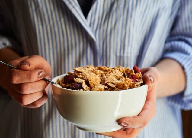 best high protein cereal: person eating cereal from a bowl