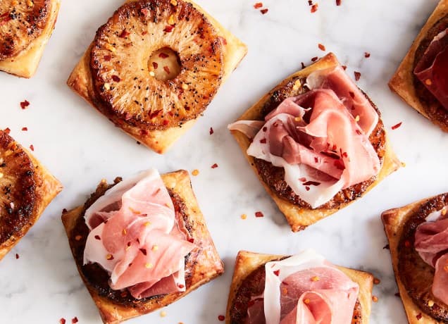 cold appetizers: spicy pineapple prosciutto tarts on a marble surface