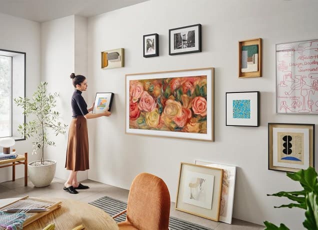 The Samsung Frame TV mounted on the wall with other artwork.