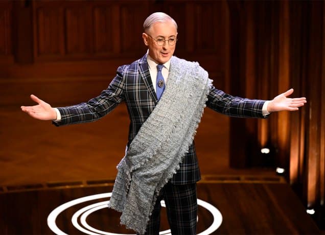 the-traitors-season-2-cast-ranked: Alan Cumming in welcoming guests to the Traitor house in a plaid suit and Scottish fabric sash.