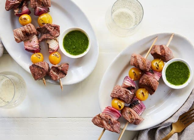 what to cook this week august 5-11: two plates with steak skewers and herb sauce