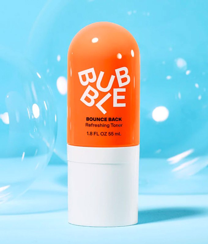 10 Products for Sensitive Skin - A rounded cylindrical container of Bubble toner. It's an orange bottle with a white cap and white labeling. It's featured in front of a blue background that's filled with actual bubbles.