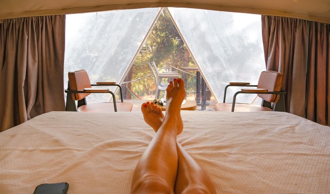 best-fall-activities: a woman relaxing in a hotel bed.