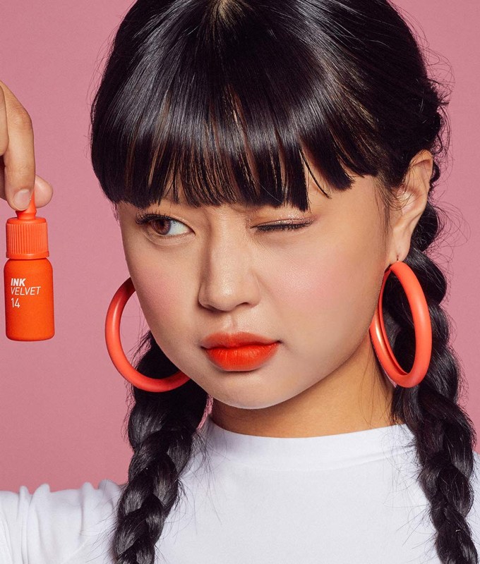 best korean makeup brands peripera: a young woman holding a lipstick