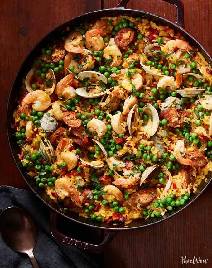 best big-batch recipes: large skillet of paella on a wooden table