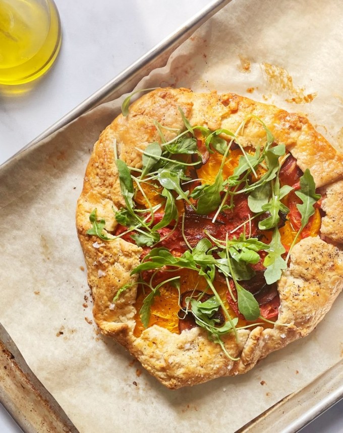 big batch recipes: BLT galette topped with arugula on a lined baking sheet