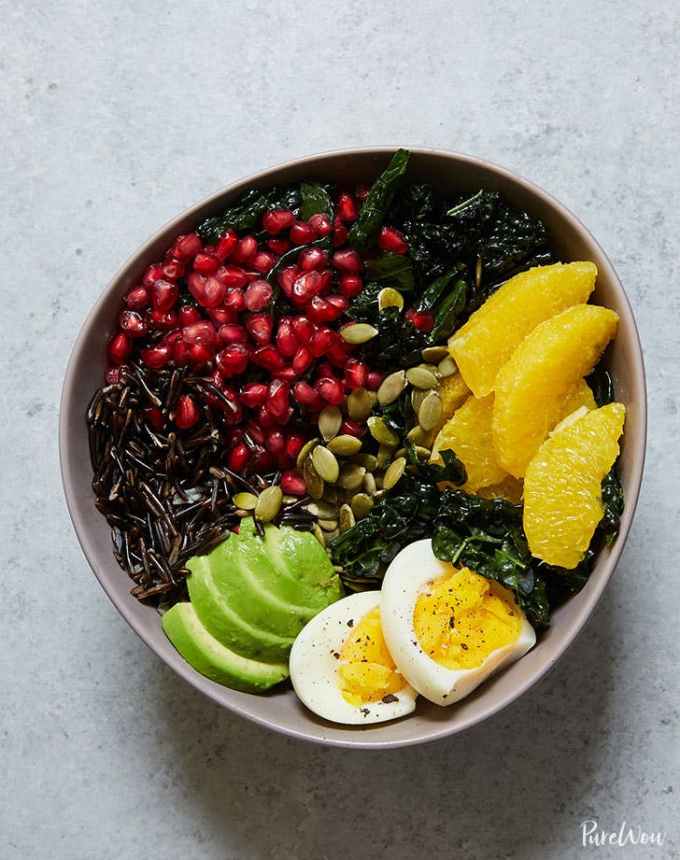 easy lunch ideas: buddha bowl with kale, avocado, orange, wild rice and pomegranate arils