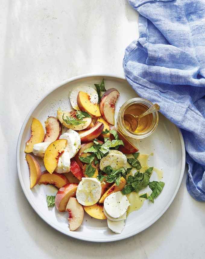 easy lunch ideas: aerial pf peach caprese salad on a plate with a blue linen