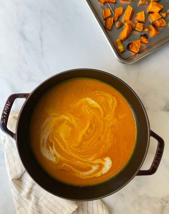 easy lunch ideas: pot of curried butternut squash soup next to a sheet pan of roasted butternut squash