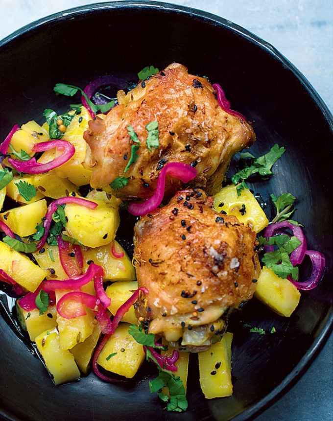 easy lunch ideas: two indian-spiced chicken thighs on a plate with mango salsa