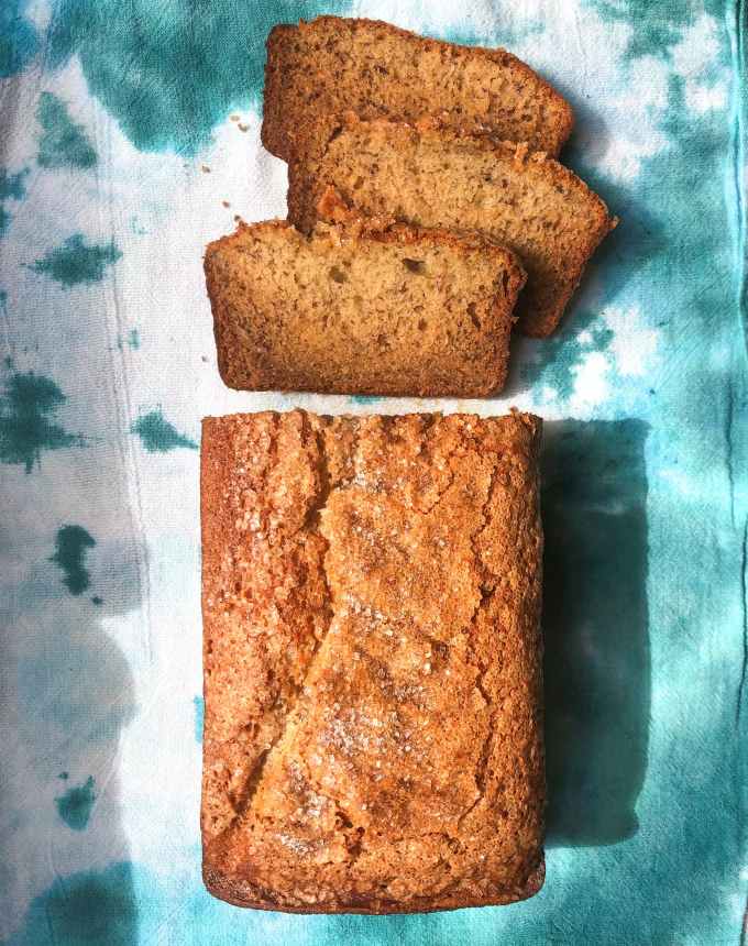 fun things to bake: a loaf of banana bread on a blue and white tie-dye towel, with a few pieces sliced off