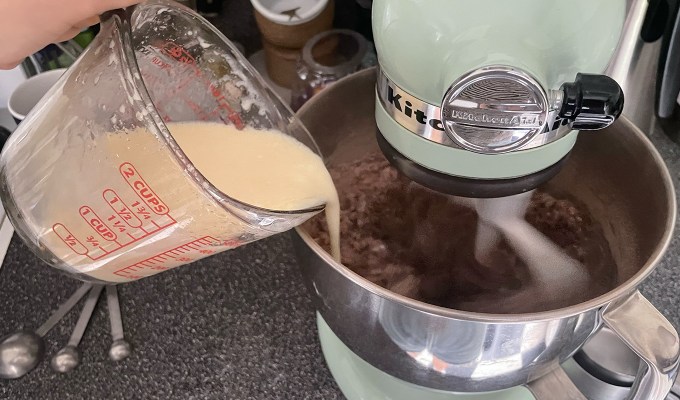 ina garten beatty's chocolate cake review: pouring the wet ingredients into the mixer