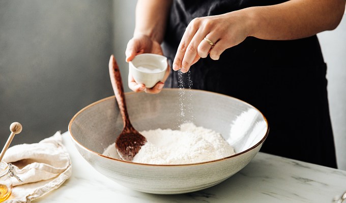 Ina Garten cooking tips: a person adding salt to a baking recipe