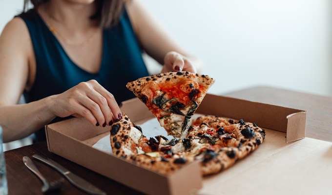 Ina Garten cooking tips: a woman eating takeout pizza