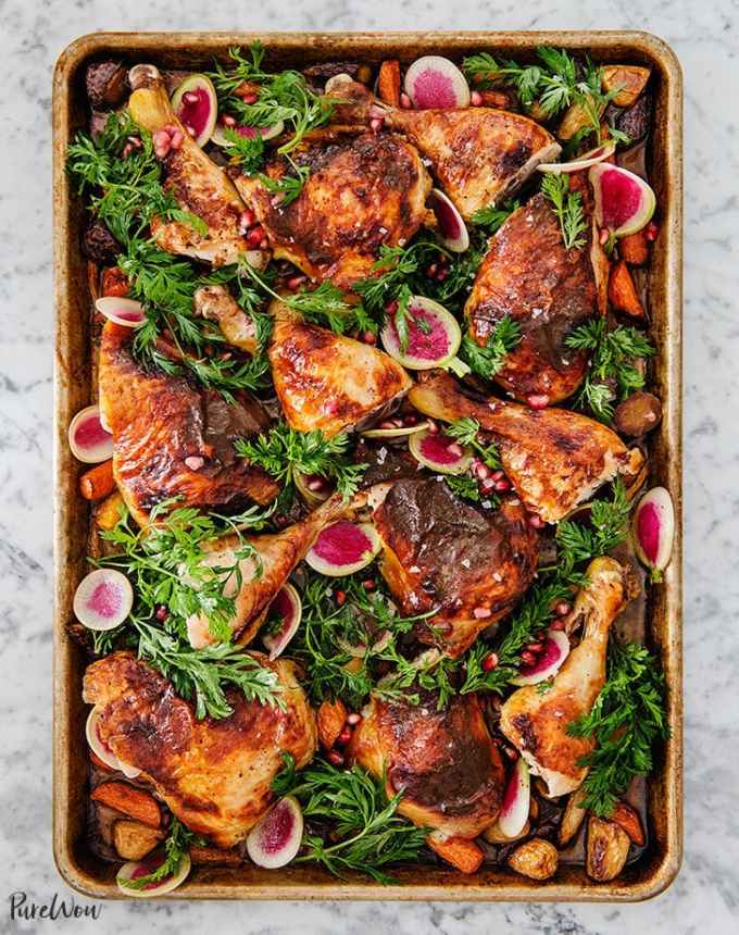 best big-batch recipes: baking sheet of roasted pomegranate chicken pieces, topped with herbs and radishes