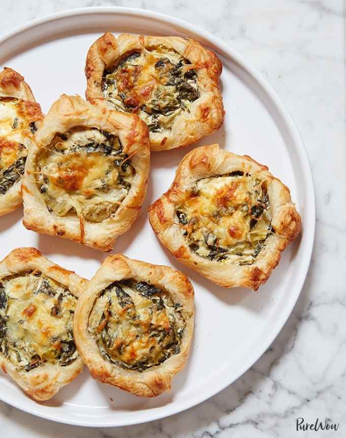 best big-batch recipes: six spinach-artichoke puff pastry squares on a white plate