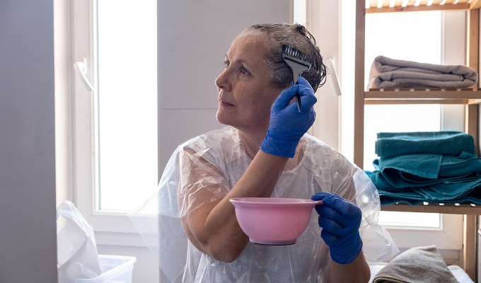 Should I Wash My Hair Before Dyeing It 1: an older woman coloring her hair at home