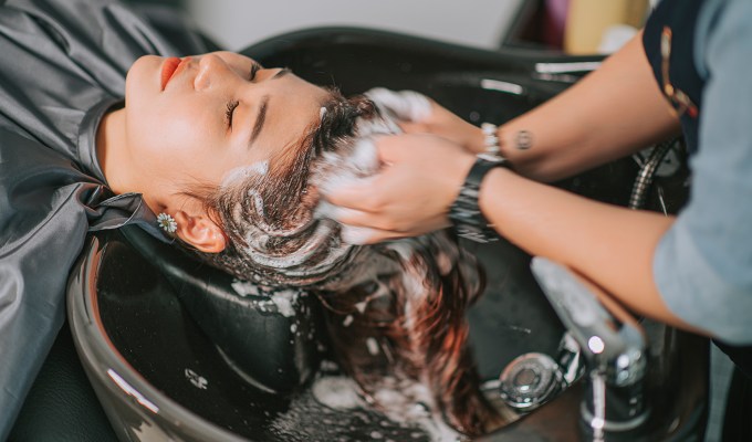 Should I Wash My Hair Before Dyeing It 2: a woman getting her hair shampooed at a salon