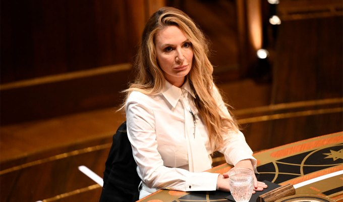 the-traitors-season-2-cast-ranked: A photo of Kate Chastain sitting at the roundtable wearing a white top.