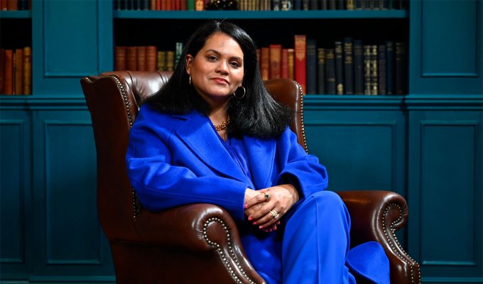 the-traitors-season-2-cast-ranked: A photo of Sandra Diaz-Twine sitting in a leather chair wearing a bright blue suit.