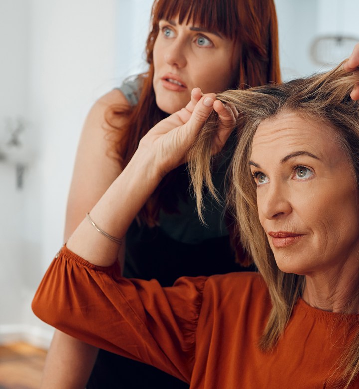 What Not to Say to a Hairstylist universal image: a woman showing her hair to her hairstylist