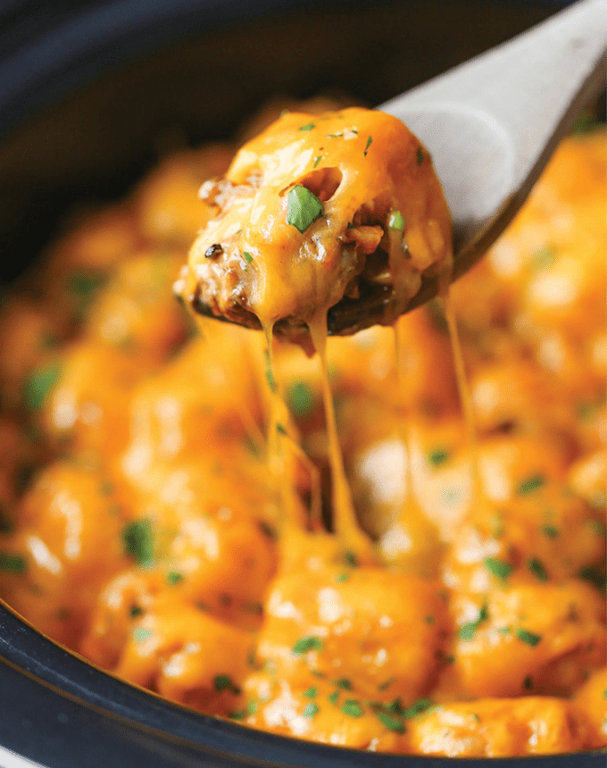 best big-batch recipes: close-up of a scoop of slow cooker tater tot casserole being removed